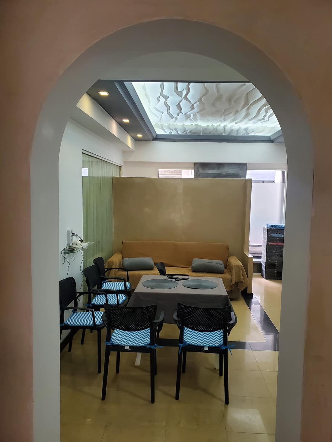 Arched doorway looking into the lounge with dining table and sculpted ceiling
