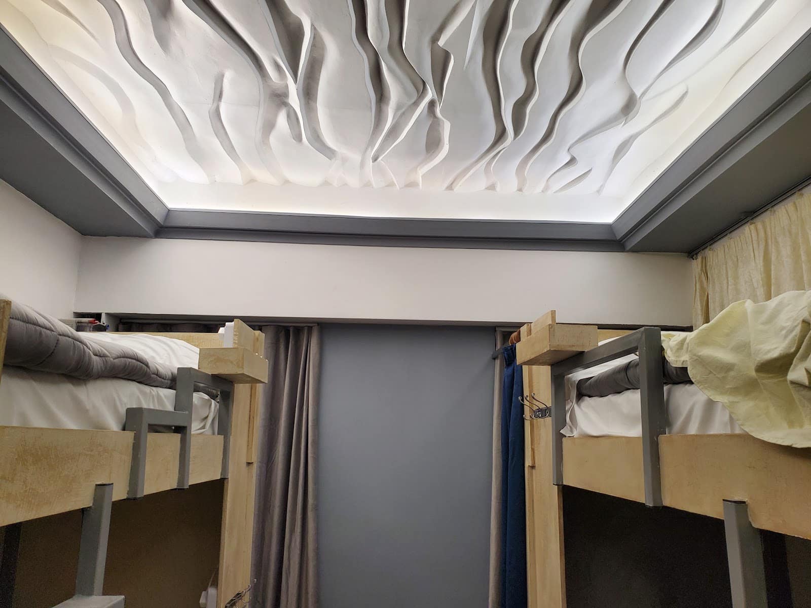 Sculpted white plaster ceiling in flowing folds above the bunk beds