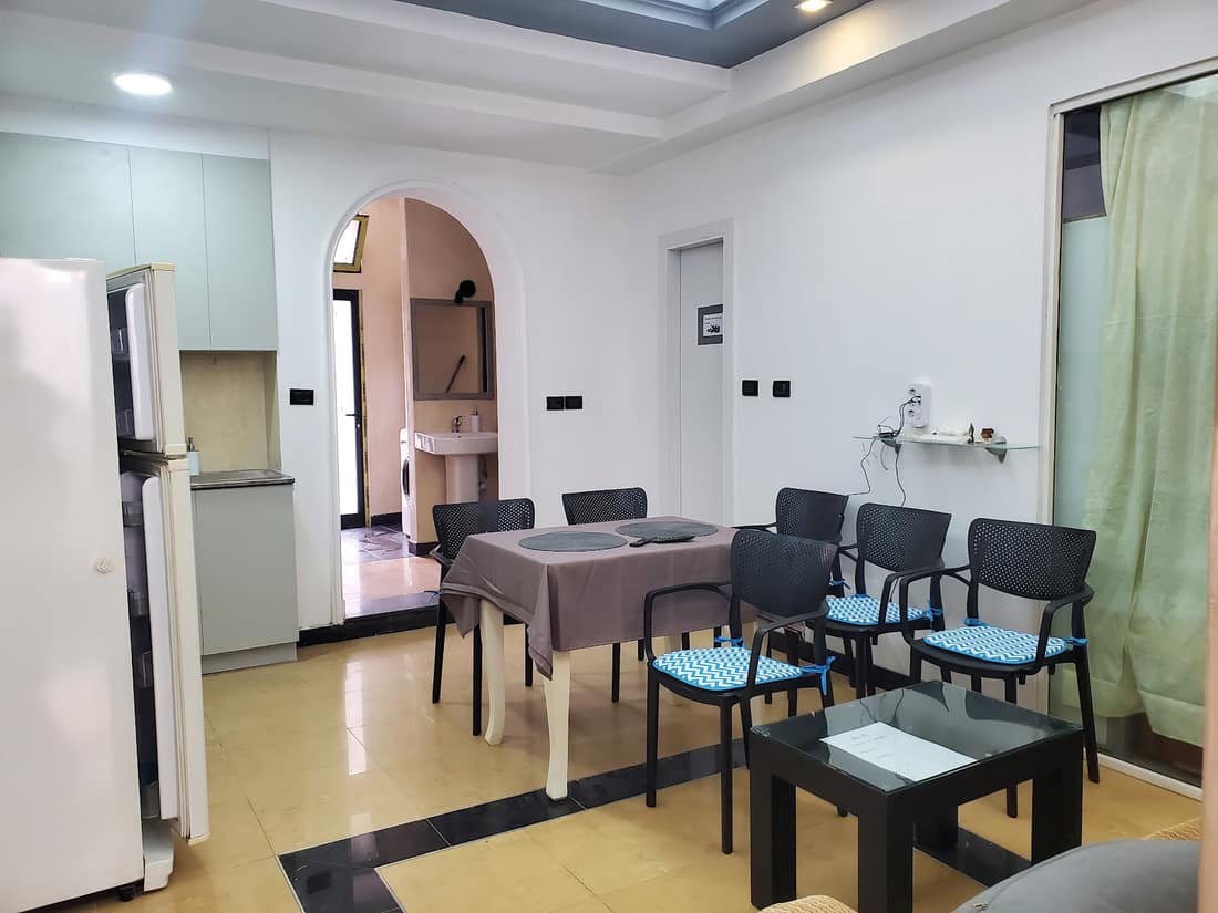 Dining table and chairs in the lounge with an arched doorway