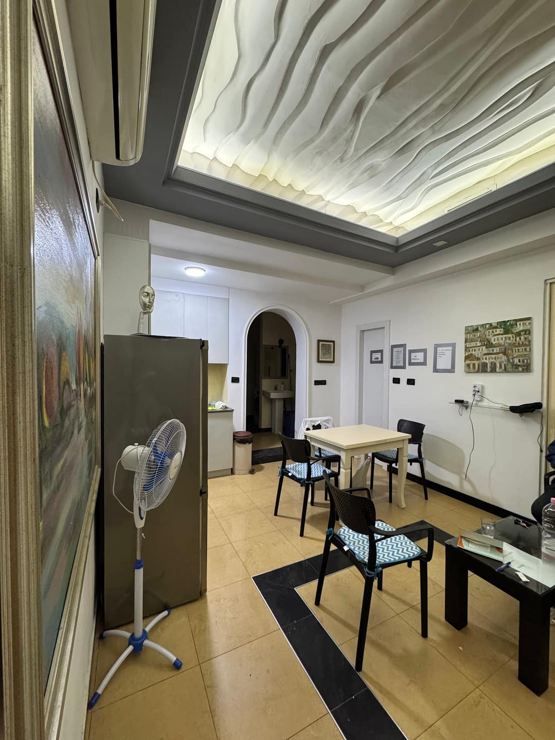 Lounge with tables, chairs and a lit sculpted ceiling