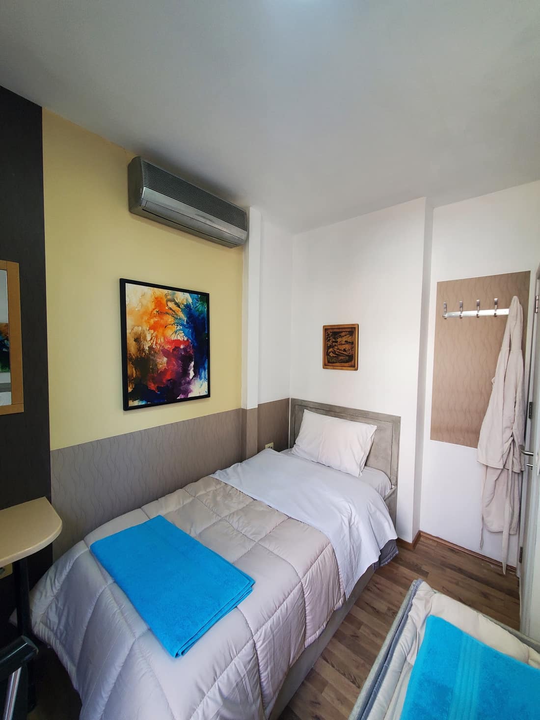 Private room with a bright painting and blue bedding