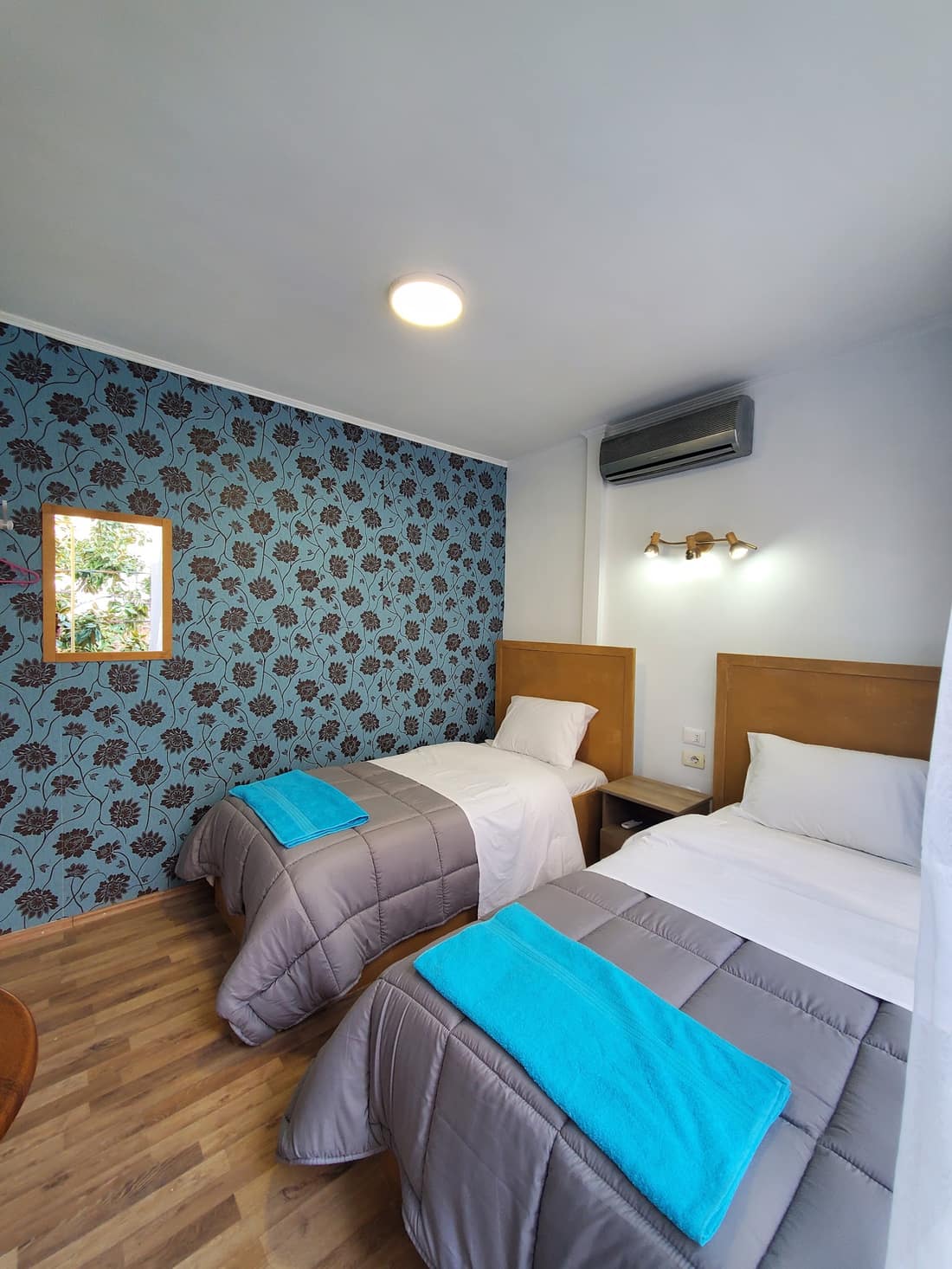 Twin room with two single beds and blue patterned wallpaper
