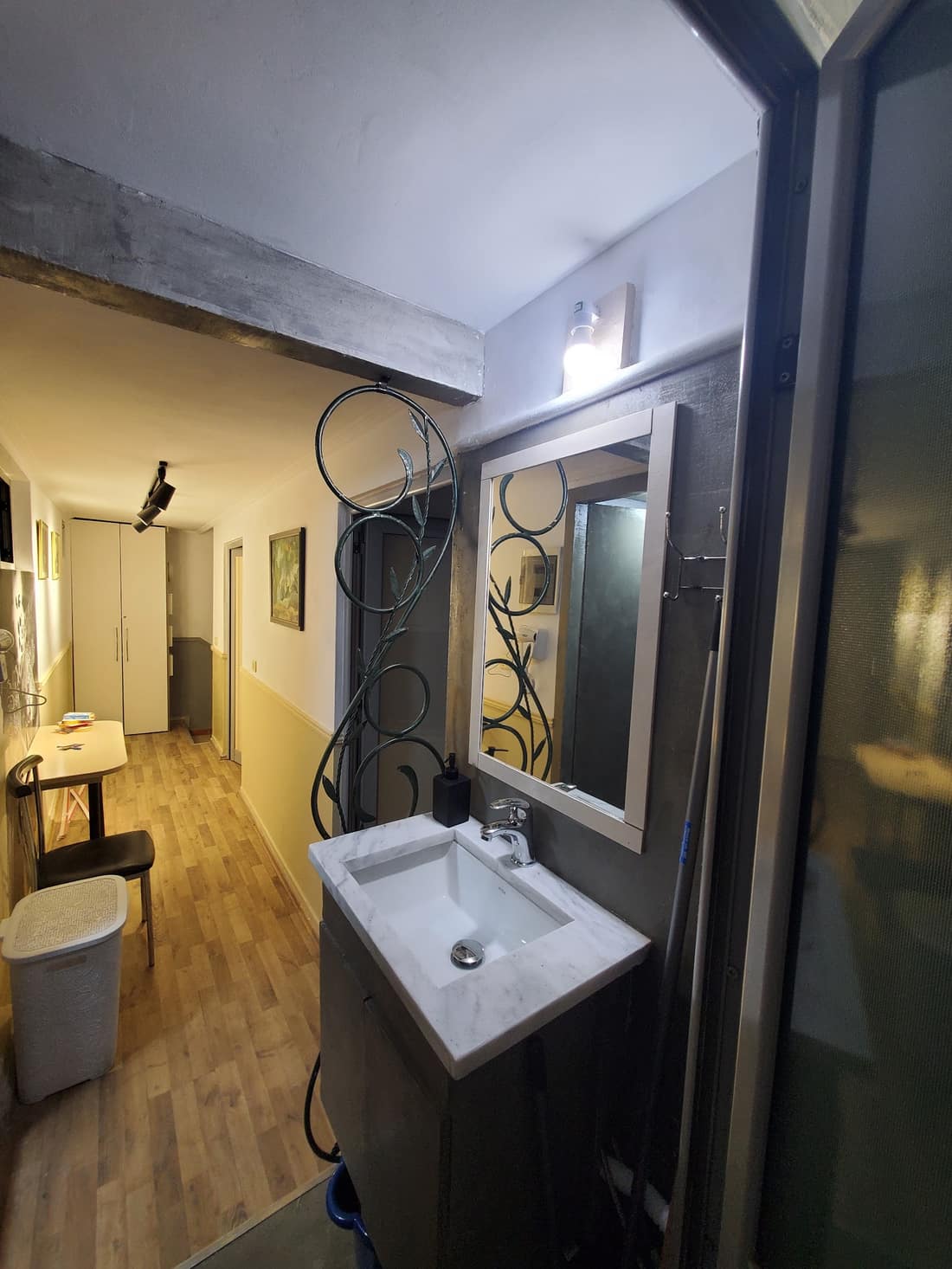 Vanity area with a mirror in a wrought-iron frame